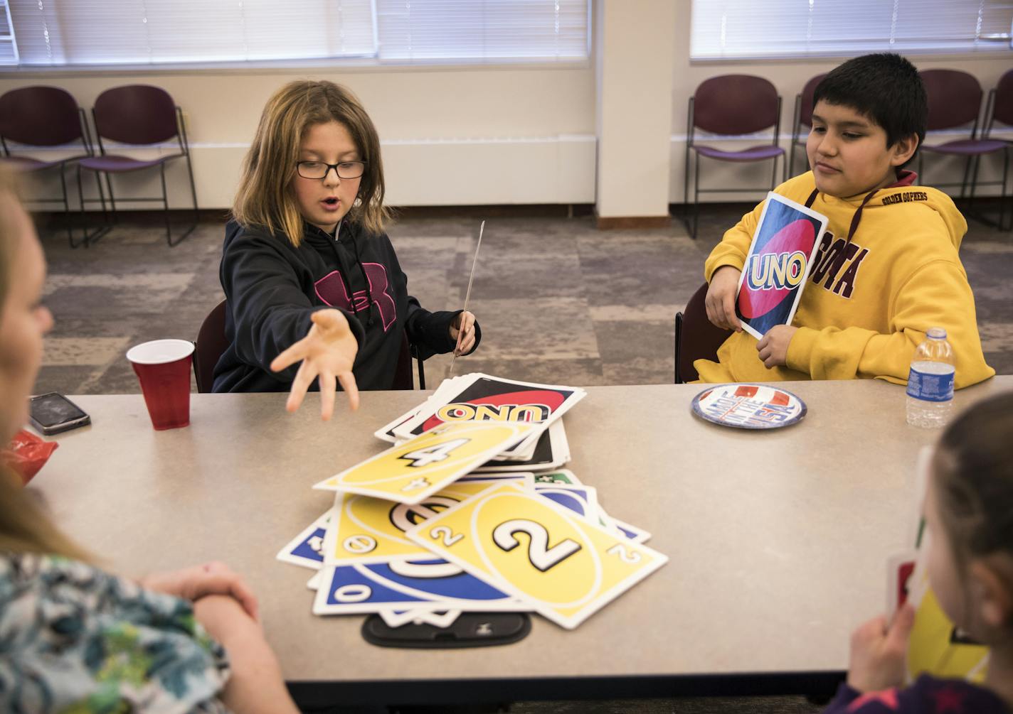 Kaelynn Gottwald, 10, laid down a card as she played a game of Uno with Angel Rios, 11, at right, and other friends after school as part of Healthy Together WIllmar on Wednesday, February 21, 2018, in Willmar, Minn.