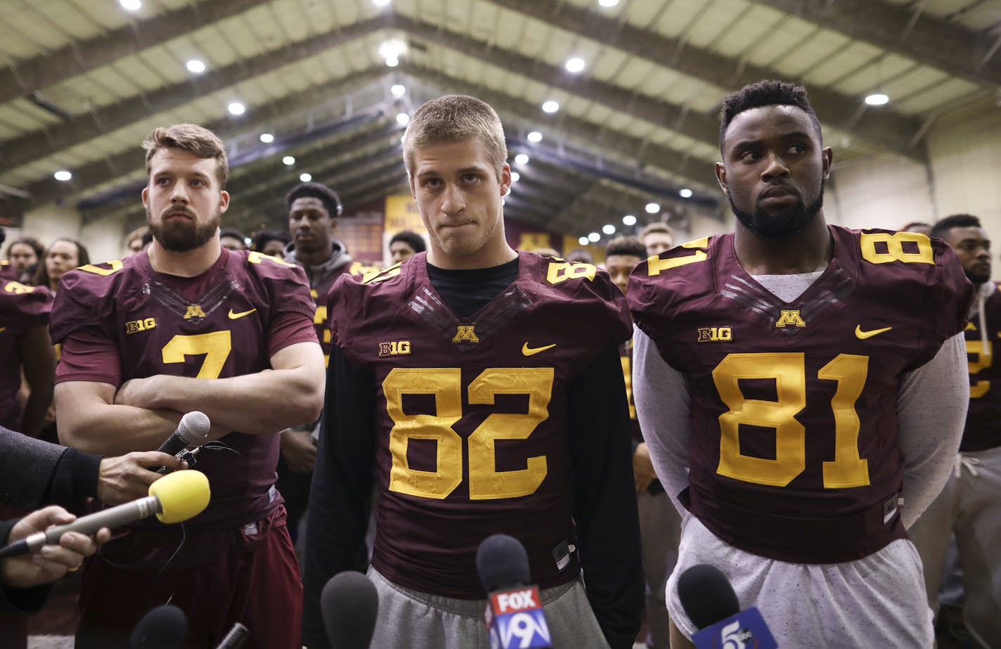 Wide receiver Drew Wolitarsky, center, flanked by quarterback Mitch Leidner, left, and tight end Duke Anyanwu, waited for team members to file in to join them before he read the statement on behalf of the players. ] JEFF WHEELER &#xef; jeff.wheeler@startribune.com Members of the University of Minnesota football team stood in the Nagurski Football Complex with Drew Wolitarsky as he read a statement Thursday night, December 15, 2016 that players would not be participating in any football activitie