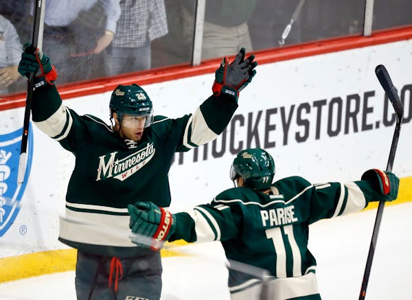 Jason Pominville (left) is greeted by teammate Zach Parise (11) during third period action after scoring the eventual game-winning goal against Montre