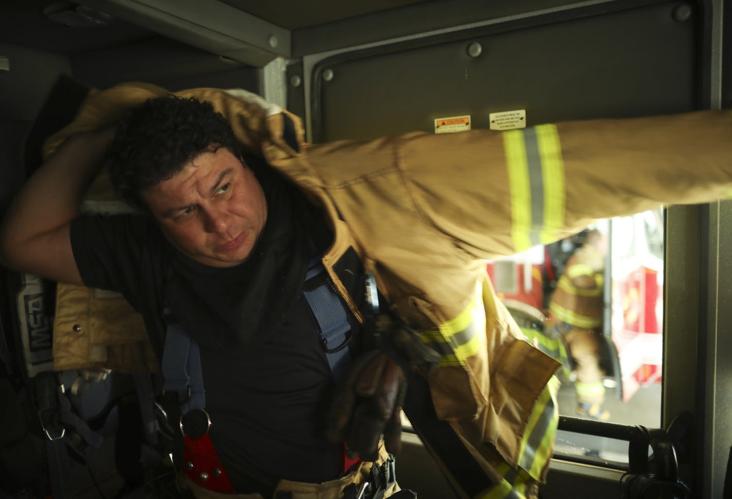 St. Paul Firefighter/Paramedic Rich Cisneros put on his protective clothing inside Engine 8 before it headed out on a fire call Monday afternoon. ] JEFF WHEELER &#xef; jeff.wheeler@startribune.com In a business where a one minute delay could be devastating, the St. Paul Fire Department's emergency response time lags two minutes behind national standards. Station 8 in downtown St. Paul is one of the busiest fire stations in the city. The Star Tribune rode along on a couple of aborted runs Monday