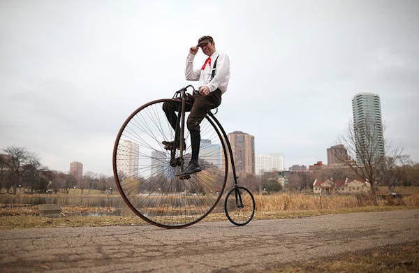 Juston Anderson on an 1890 Victor high wheeler bicycle in Loring Park.