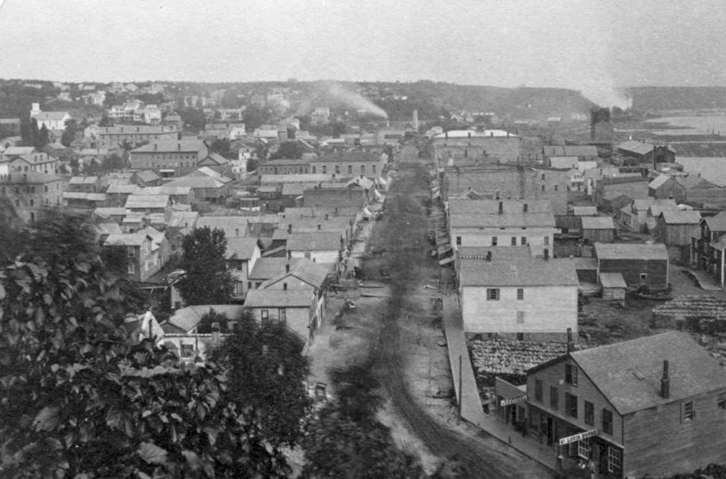 An 1800s view of Stillwater's Main Street. The prison, located near the bluff in the distance of this photo, is not visible.