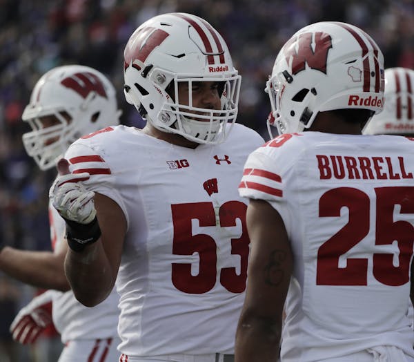 Wisconsin linebacker T.J. Edwards (53) talks with safety Eric Burrell (25) during the first half of an NCAA college football game against Northwestern