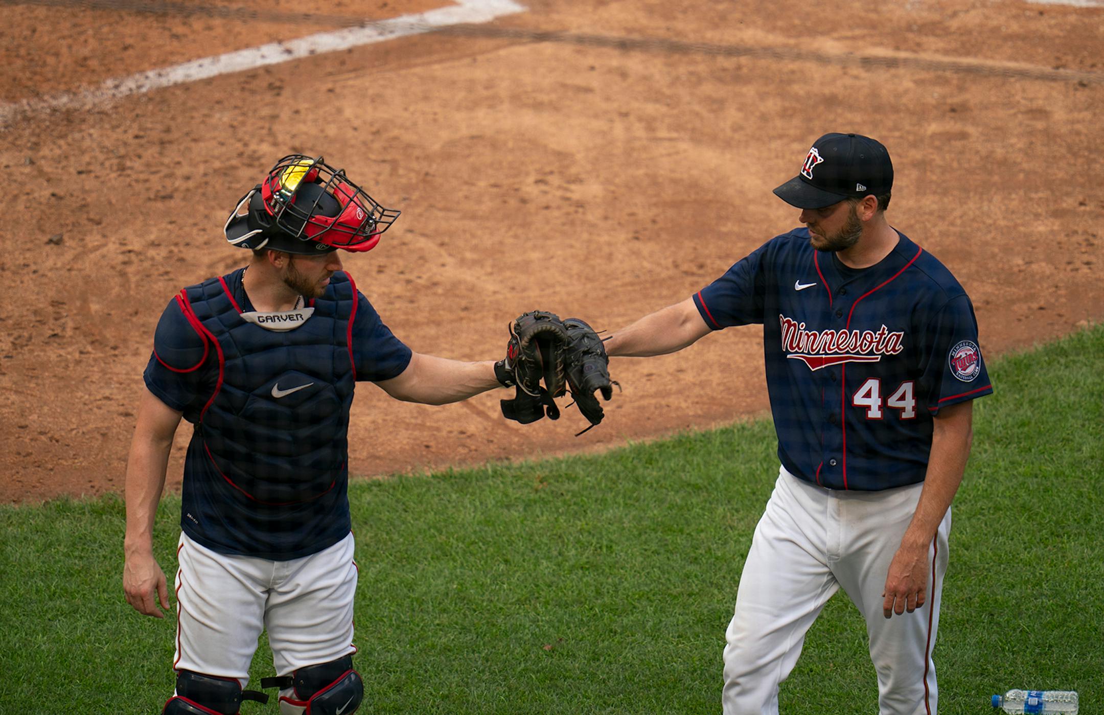 Minnesota Twins pitcher Rich Hill (44) touched gloves with catcher Mitch Garver (8) after throwing live batting practice Monday evening.