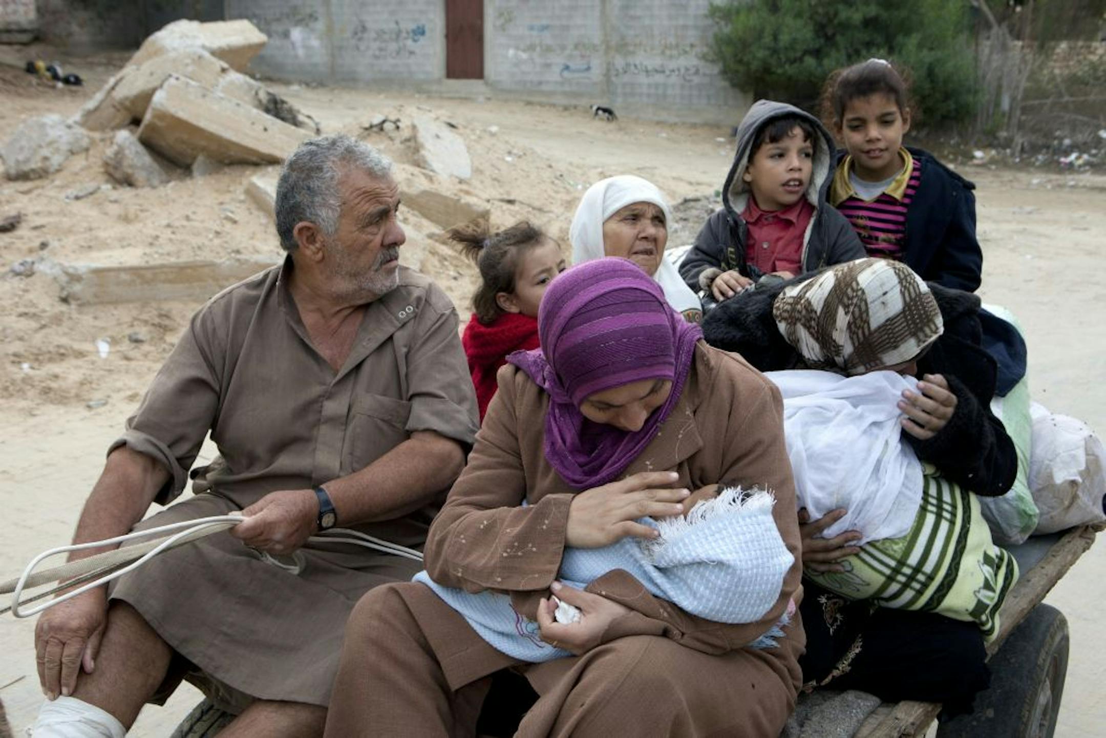 A Palestinian family leaves the area with some belongings in Gaza City, Gaza Strip, Nov. 17, 2012. Israel responded to rocket attacks on Tel Aviv and Jerusalem by striking 200 targets overnight in Gaza, including the prime minister's office.