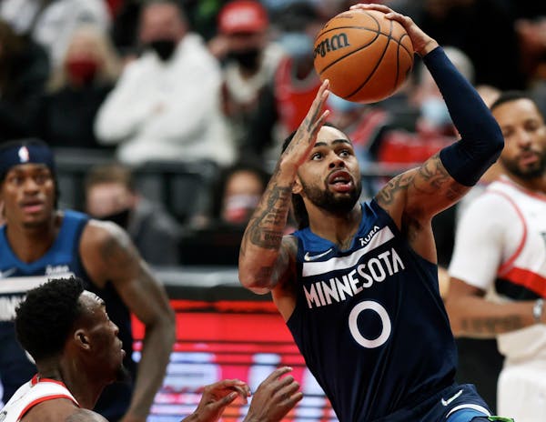 Minnesota Timberwolves guard D'Angelo Russell, right, drives to the basket past Portland Trail Blazers forward Nassir Little, left, during the first h