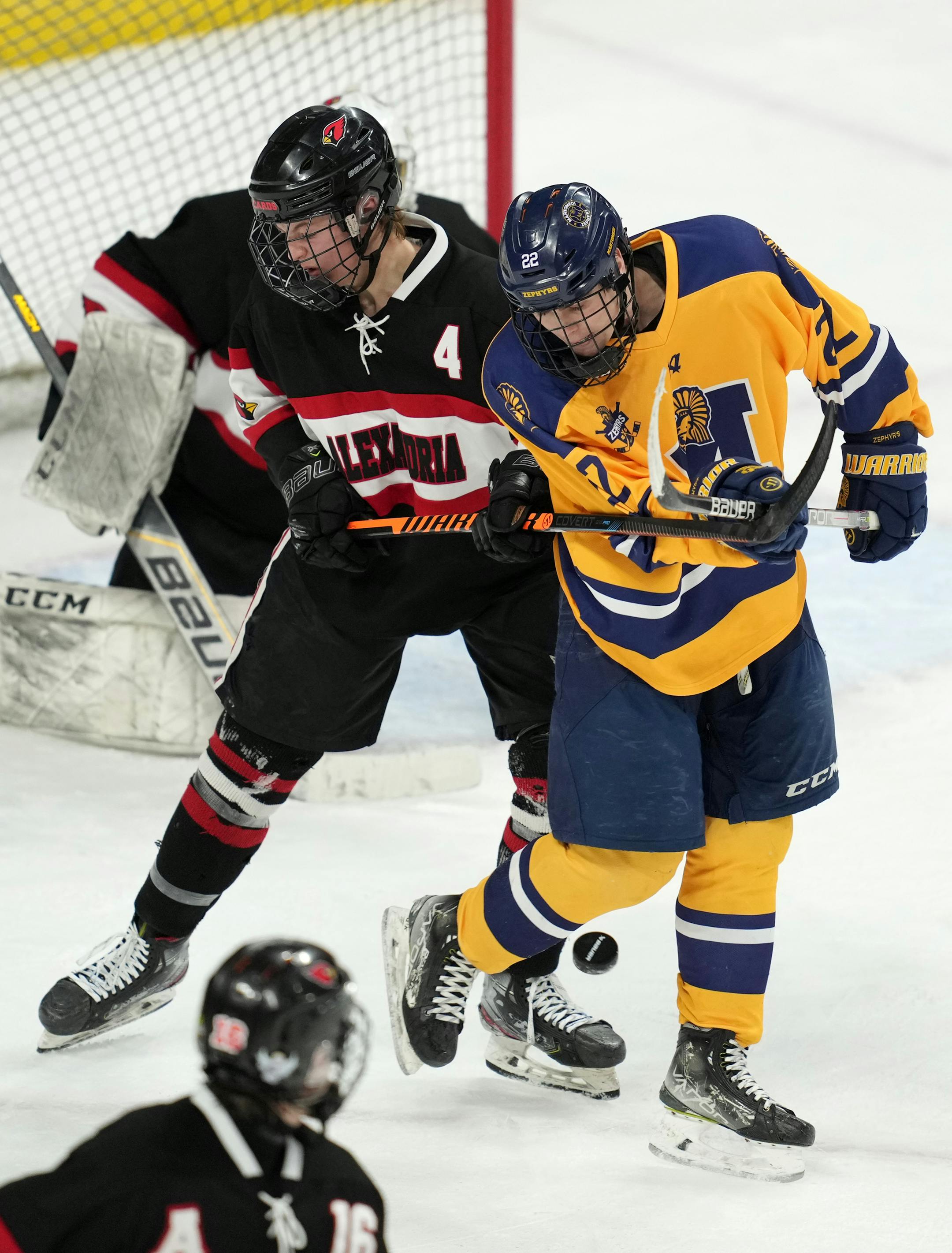 Mahtomedi forward Carter Haycraft (22) tries to deflect the puck in as Alexandria defenseman Gage Castle (4) defends in the third period of a MSHSL Class 1A quarterfinal hockey game between Alexandria and Mahtomedi.