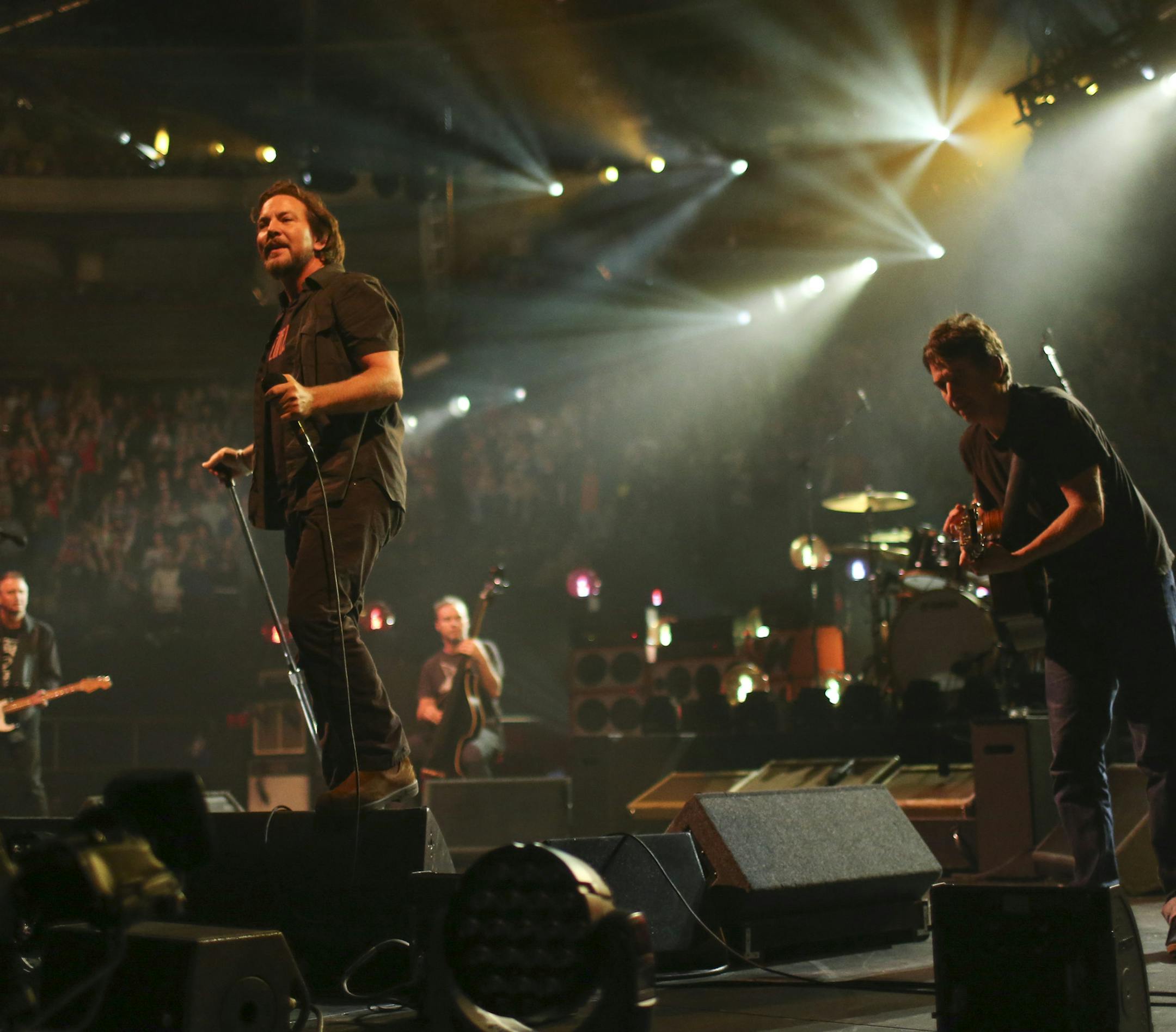 Pearl Jam's singer, Eddie Vedder, stood on a monitor early in the band's set Sunday night at Xcel Energy Center. The others are, from left, guitarist Mike McCready, bassist Jeff Ament, and guitarist Stone Gossard. ] JEFF WHEELER ‚Ä¢ jeff.wheeler@startribune.com Pearl Jam performed at Xcel Energy Center in St. Paul Sunday night, October 20, 2014.