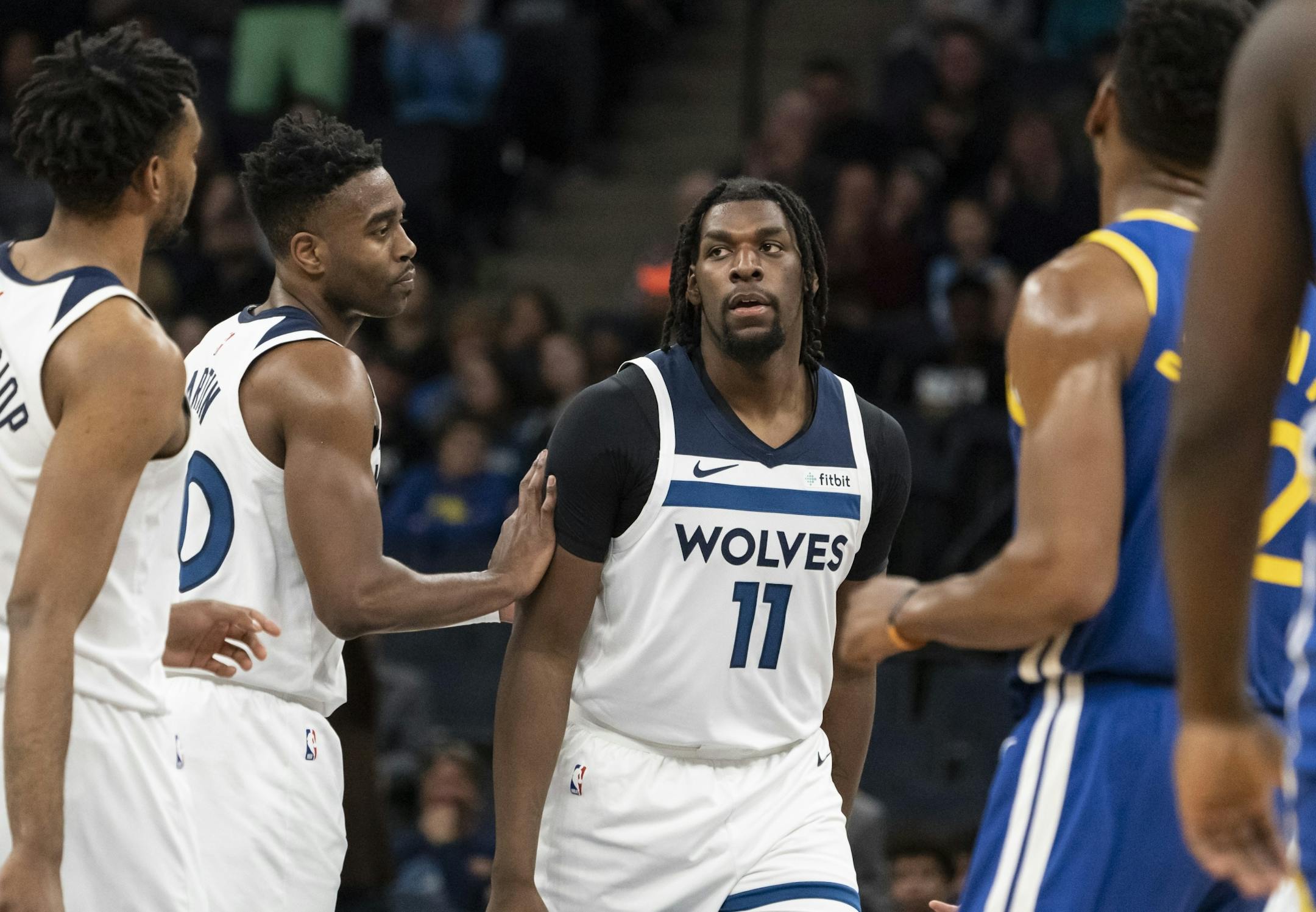 Minnesota Timberwolves center Naz Reid (11) was congratulated by Minnesota Timberwolves forward Kelan Martin (30) after a three-point shot in the first half.