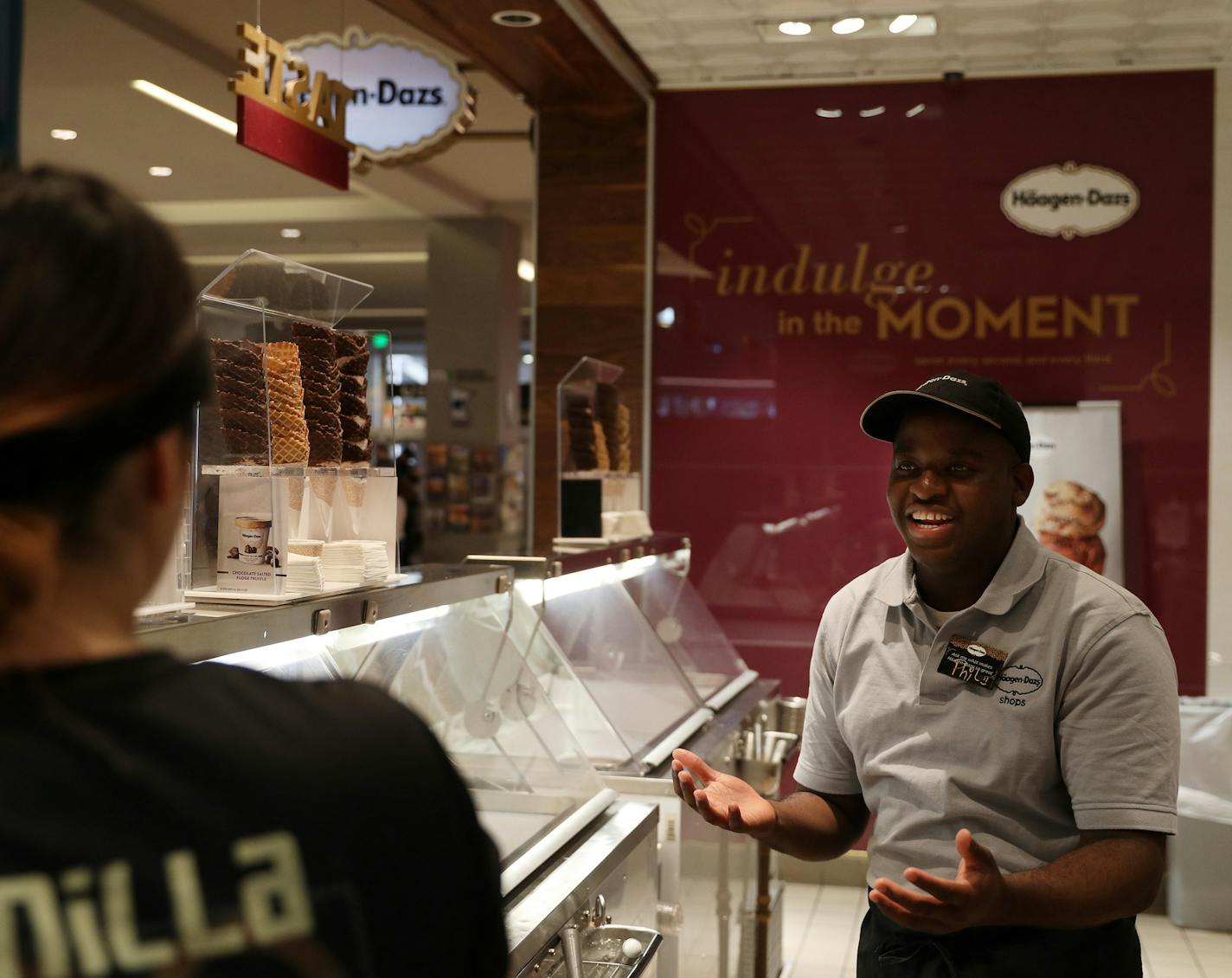 Manger Philson Cetoute, who's been with the company for four years, talked with a fellow employee while working the front counter Thursday. ] ANTHONY SOUFFLE &#xef; anthony.souffle@startribune.com Haagen-Dazs employees worked Thursday, March 29, 2018 at their location at the Mall of America in Bloomington, Minn. Corporate staff worked with an app from Design Center, Inc. that helped them improve customer service and other operations.