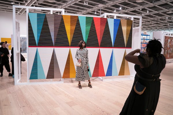 Visitors at the Whitney Museum of Art pose in front of Dyani Whitehawk's work during its Biennial in New York , NY., on Wednesday, March 30, 2022. Bar