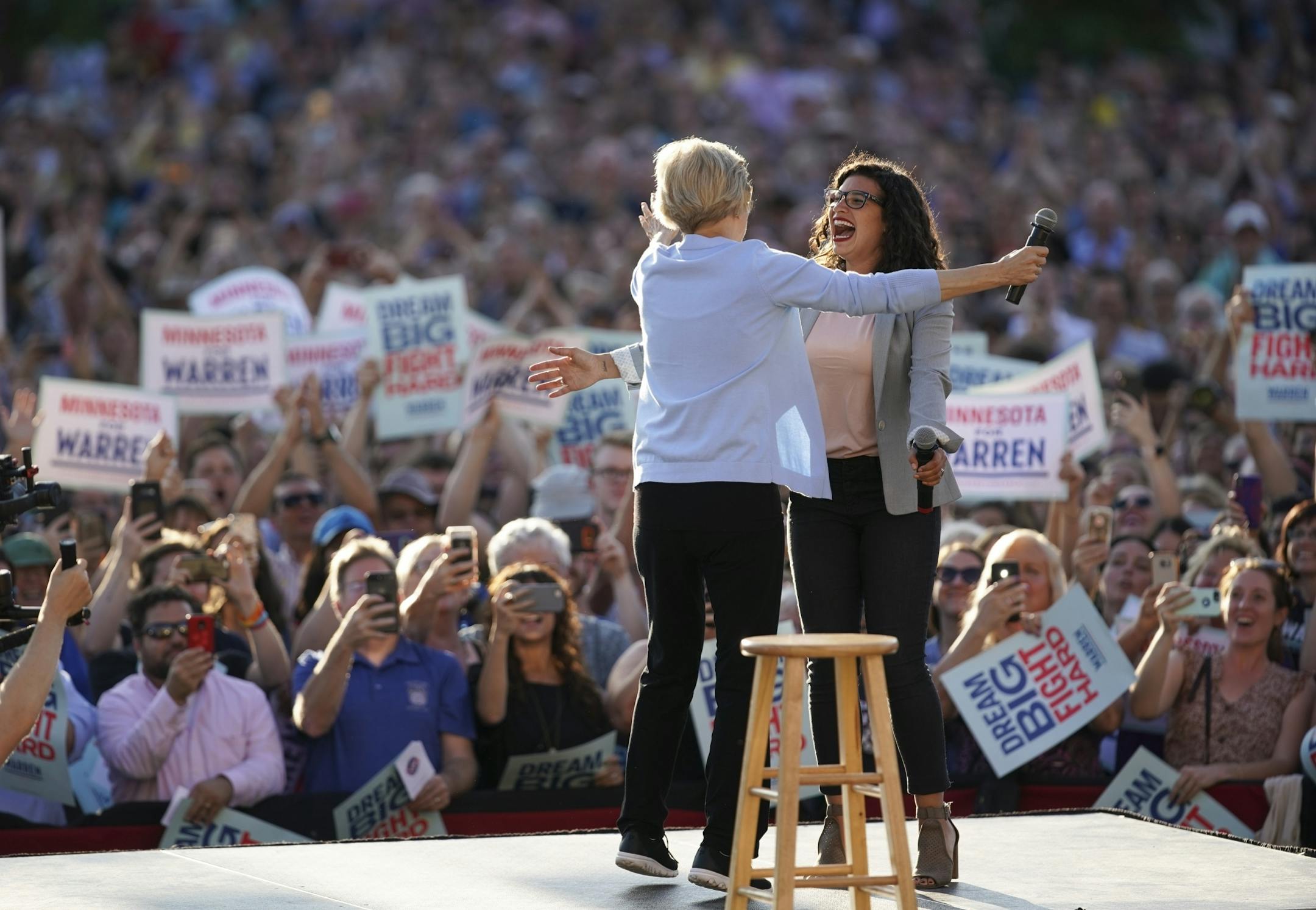 Sen. Elizabeth Warren was greeted by Erin Maye Quade, who introduced her, as she walked on stage to begin her Town Hall on Shaw Field at Macalester College Monday evening.