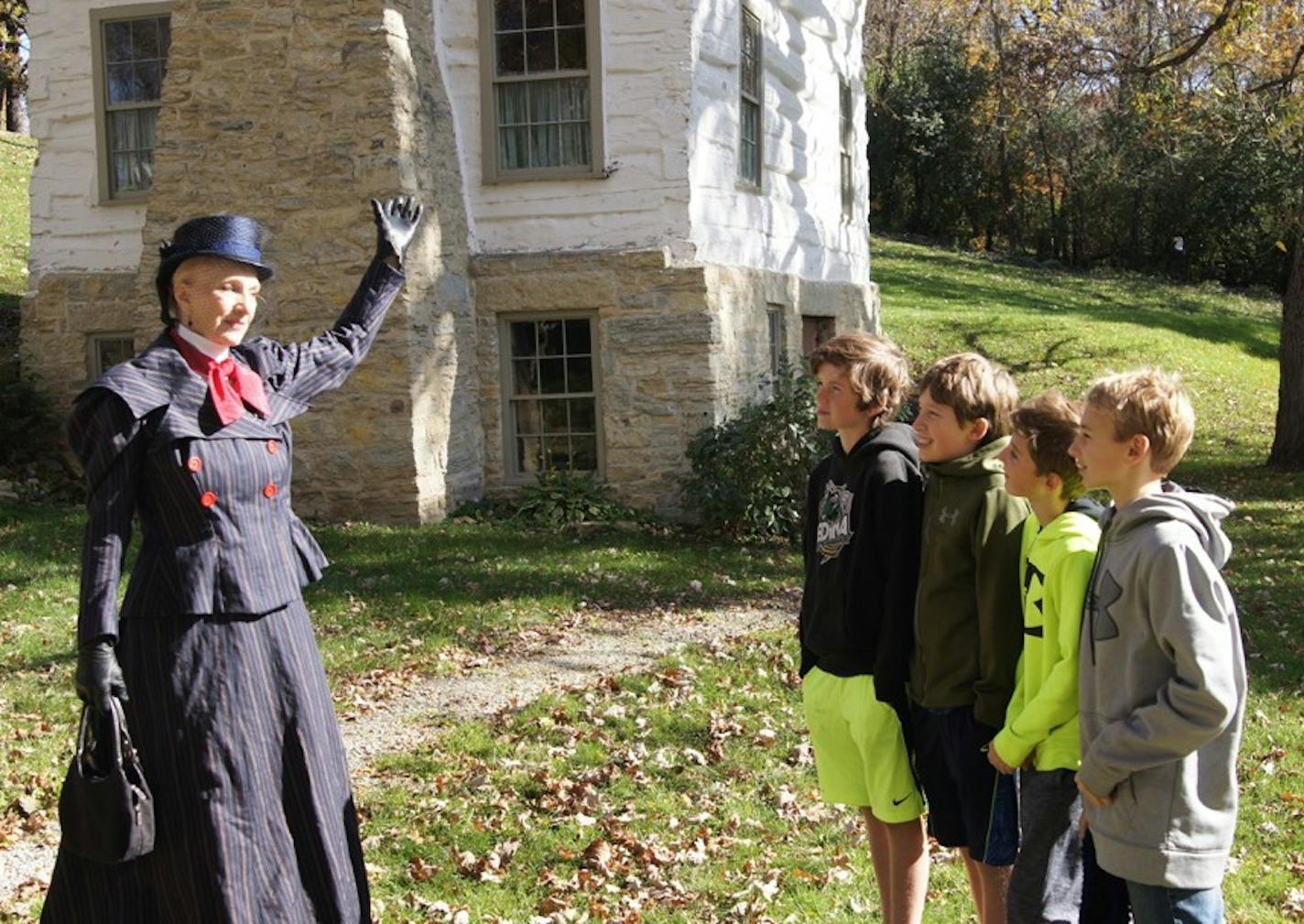 Tour guide Jane Olive, left, has a ghost story of her own for visitors at the 1850s Log Cabin in Mantorville, Minn.