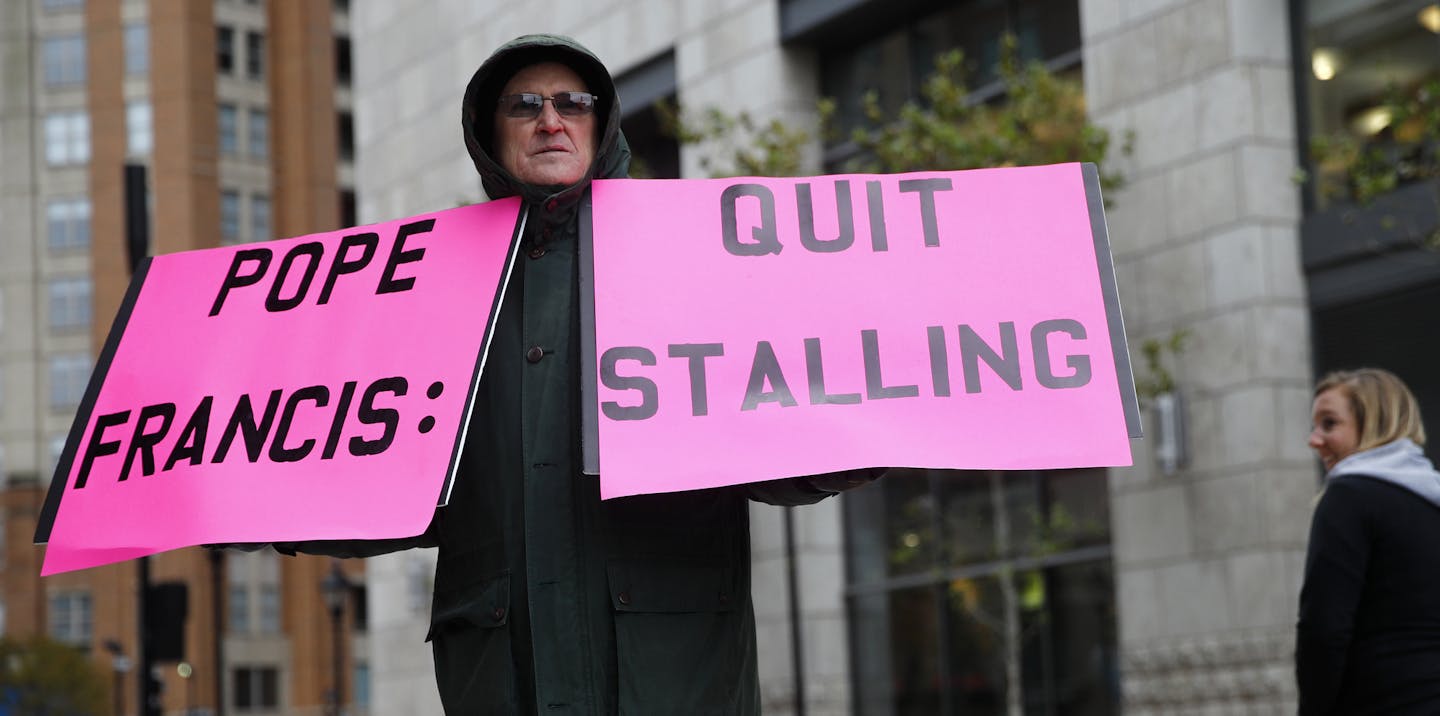 Robert Hoatson, of West Orange, N.J., holds protest signs outside of a hotel hosting the United States Conference of Catholic Bishops' annual fall meeting, Tuesday, Nov. 13, 2018, in Baltimore. (AP Photo/Patrick Semansky)