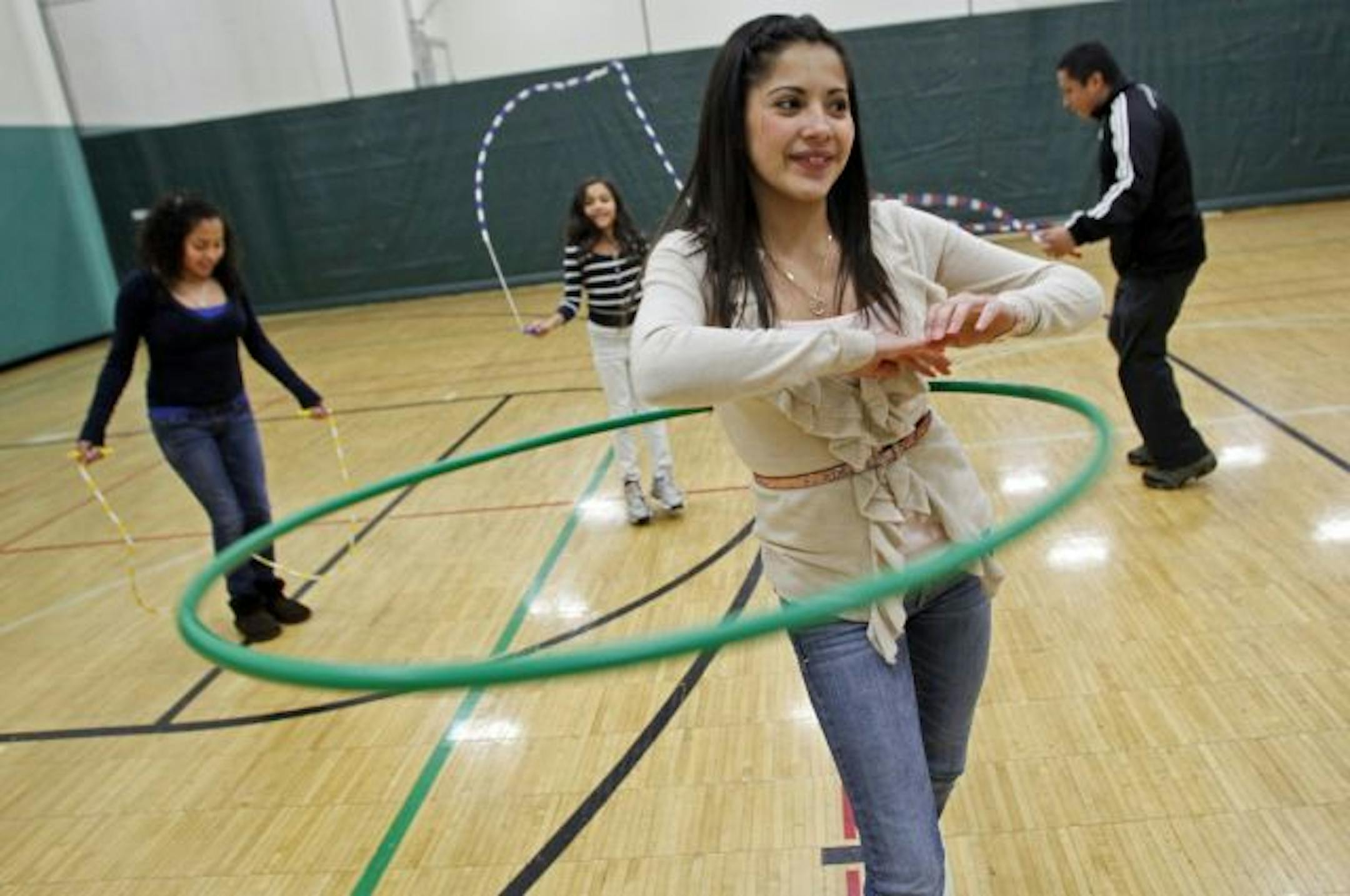 Marisol Santana-Navarro exercised with a hoola-hoop while her sisters Claudia Santana-Navarro, 13 and Jennifer Santana-Navarro, 8 and YWCA program director Luis Ramirez worked out with jump ropes.