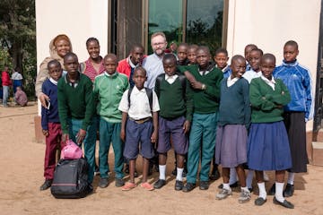 Judith Merinyo, Project Zawadi country manager, and Brian Singer, founder of safari-business Access 2 Tanzania. with Zawadi students in Tanzania.