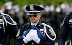 A member of a police honor guard carried a U.S. flag after funeral services for Baton Rouge police officer Matthew Gerald on Friday.