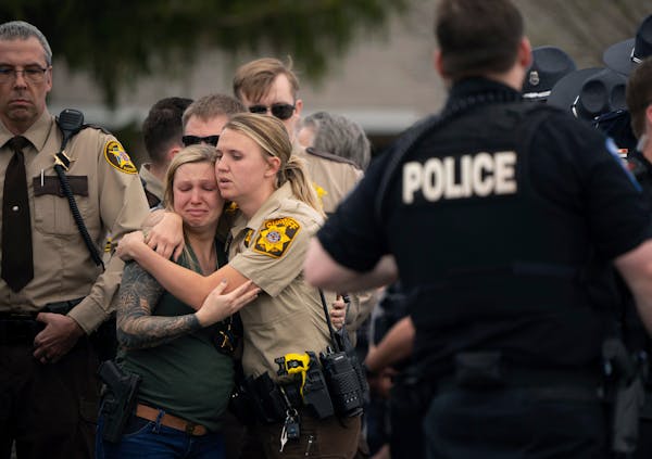 Law enforcement members comforted each other after St. Croix County deputy Kaitie Leising’s body was carried into a Baldwin, Wis., funeral home Sund