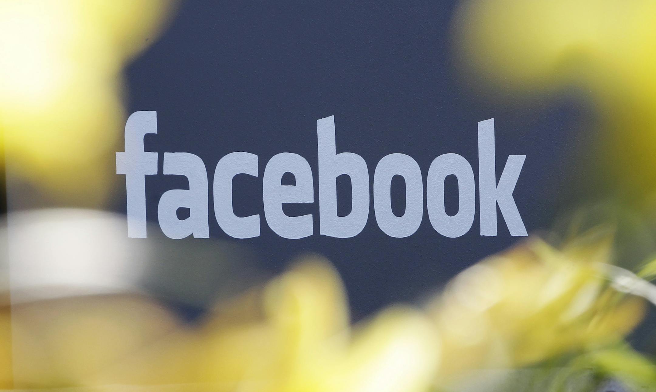 FILE - This Friday, May 18, 2012, file photo shows a sign at Facebook's headquarters behind flowers in Menlo Park, Calif. Facebook users in the U.S. will soon receive Amber Alerts to help find missing children who may be located near them, the company announced Tuesday, Jan. 13, 2015. (AP Photo/Paul Sakuma, File)