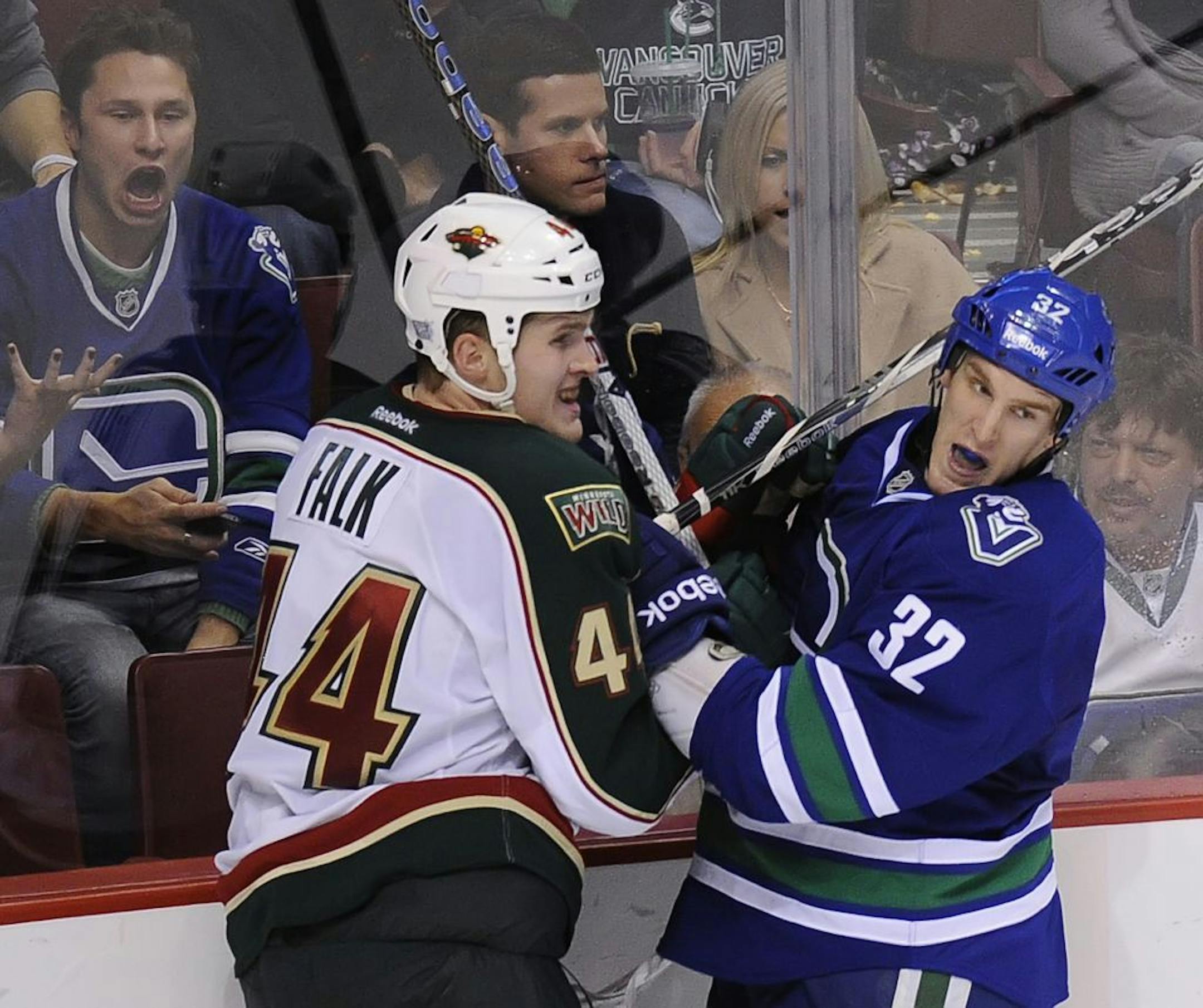 Vancouver Canucks' Dale Weise (32) battles Minnesota Wild's Justin Falk during overtime at Rogers Arena in Vancouver, British Columbia, Canada, on Saturday, October 22, 2011. The Canucks won in overtime, 3-2.