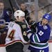 Vancouver Canucks' Dale Weise (32) battles Minnesota Wild's Justin Falk during overtime at Rogers Arena in Vancouver, British Columbia, Canada, on Sat