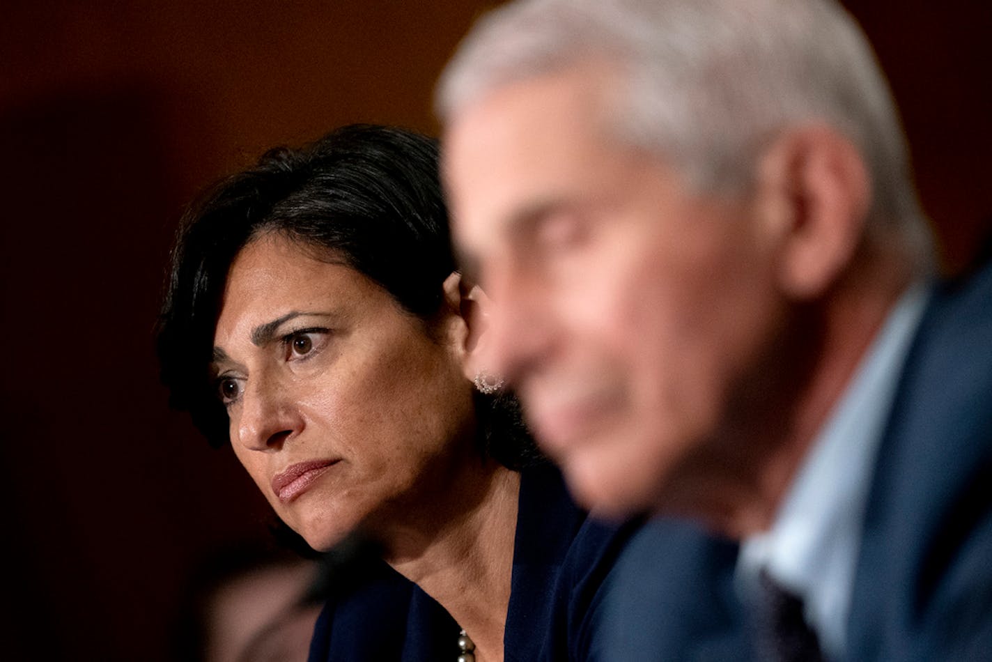 Dr. Rochelle Walensky, the director of the Centers for Disease Control and Prevention, and Dr. Anthony Fauci, director of the National Institute of Allergy and Infectious Diseases, appear before the Senate Health, Education, Labor, and Pensions Committee in Washington on Tuesday, July 20, 2021. Revising a decision made just two months ago, the CDC said on Tuesday that people vaccinated against the coronavirus should resume wearing masks in public indoor spaces in parts of the country where the virus is surging. (Stefani Reynolds/The New York Times)