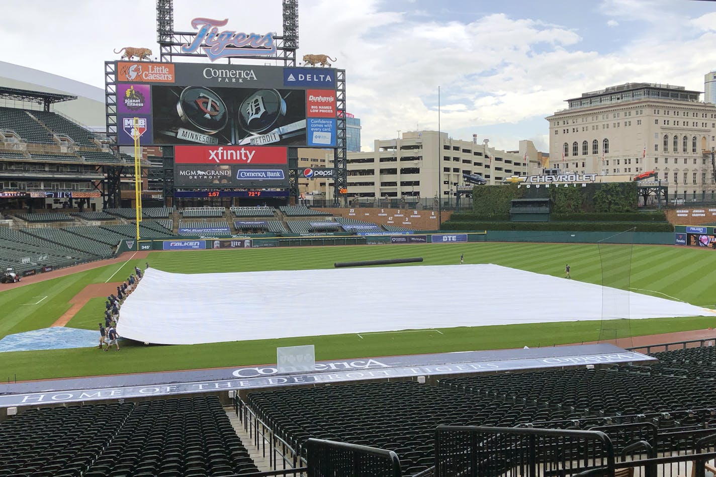 The Detroit Tigers grounds crew pulls the tarp back on the field after an initial draining before the first game of a doubleheader baseball game against the Minnesota Twins, Friday, Aug. 28, 2020 in Detroit. Both games of the doubleheader have been postponed. (AP Photo/Carlos Osorio)