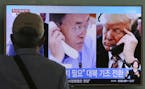 A man watches a television screen showing U.S. President Donald Trump, right, and South Korean President Moon Jae-in during a news program at the Seou