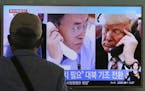 A man watches a television screen showing U.S. President Donald Trump, right, and South Korean President Moon Jae-in during a news program at the Seou