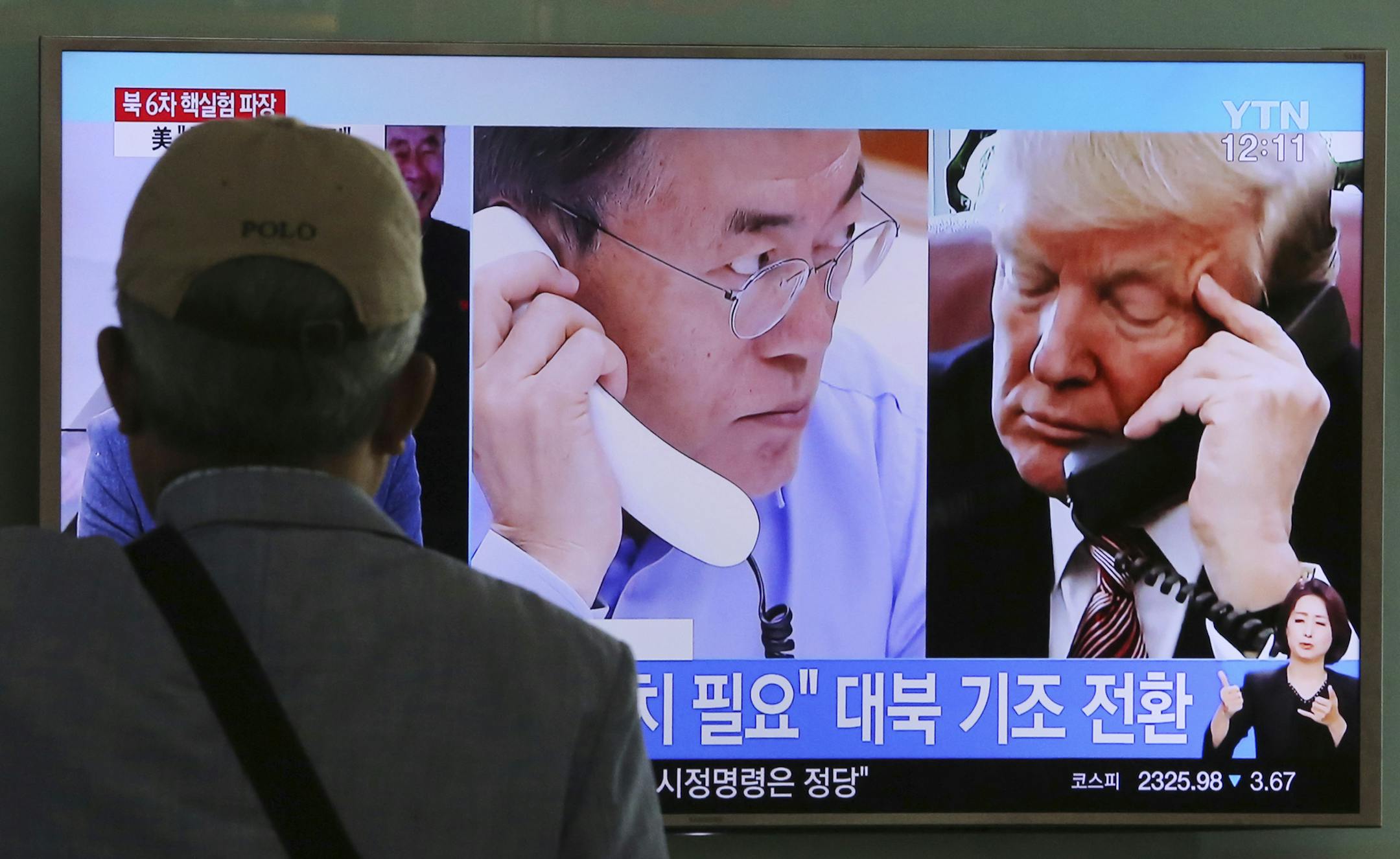 A man watches a television screen showing U.S. President Donald Trump, right, and South Korean President Moon Jae-in during a news program at the Seoul Railway Station in Seoul, South Korea, Tuesday, Sept. 5, 2017. The signs read "Need sanctions on North Korea."(AP Photo/Ahn Young-joon)
