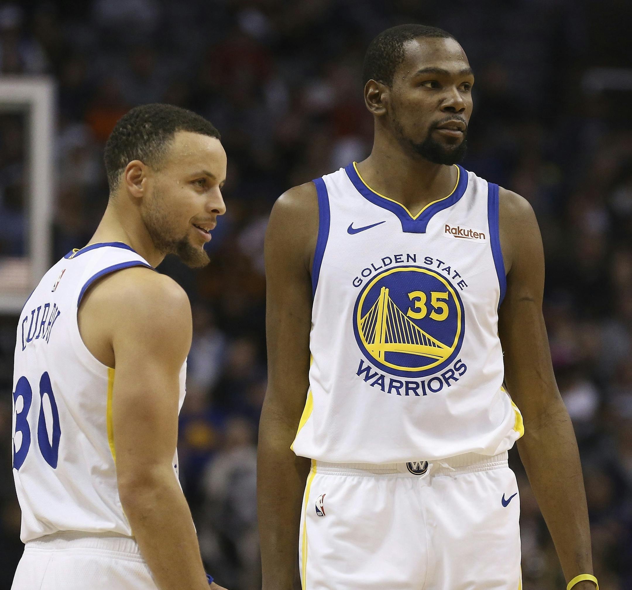 FILE - In this Feb. 8, 2019, file photo, Golden State Warriors guard Stephen Curry (30) and forward Kevin Durant (35) pause during the first half of an NBA basketball game against the Phoenix Suns Friday, Feb. 8, 2019, in Phoenix. Someday, years or even decades from now, at one of those celebratory reunions teams like to do, Stephen Curry knows he and Kevin Durant will reminisce with fondness about their three insanely successful years together on the Golden State Warriors. They will reflect on