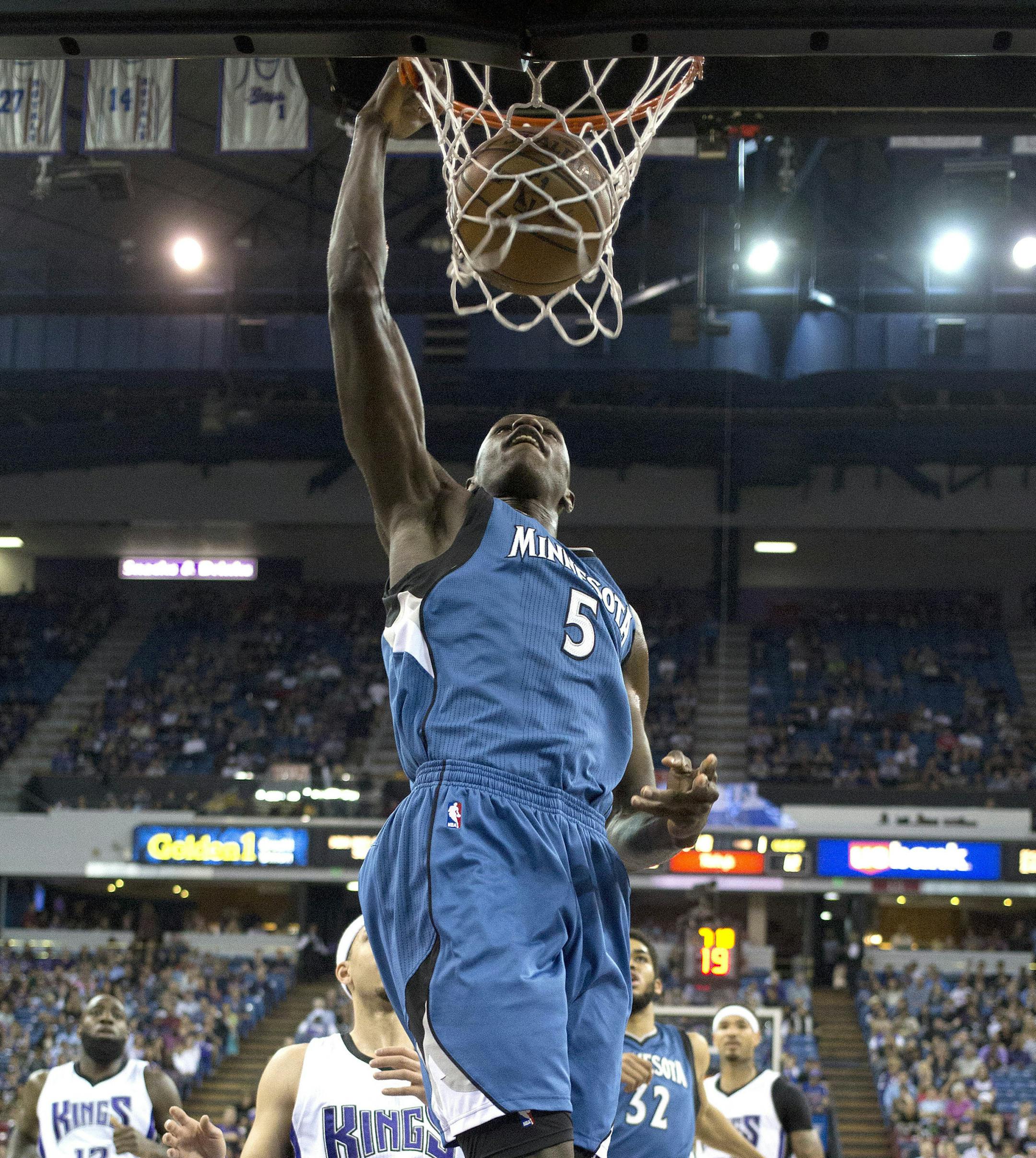 Minnesota Timberwolves center Gorgui Dieng , of Senegal, goes up for the stuff past Sacramento Kings guard Seth Curry, left, during the first quarter of an NBA basketball game Thursday, April 7, 2016, in Sacramento, Calif. (AP Photo/Rich Pedroncelli)