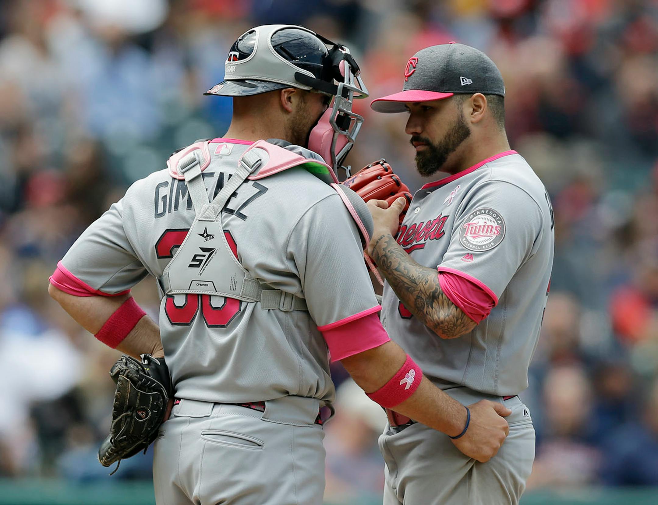Minnesota Twins catcher Chris Gimenez, left, talks with starting pitcher Hector Santiago in the second inning of a baseball game against the Cleveland Indians, Sunday, May 14, 2017, in Cleveland.