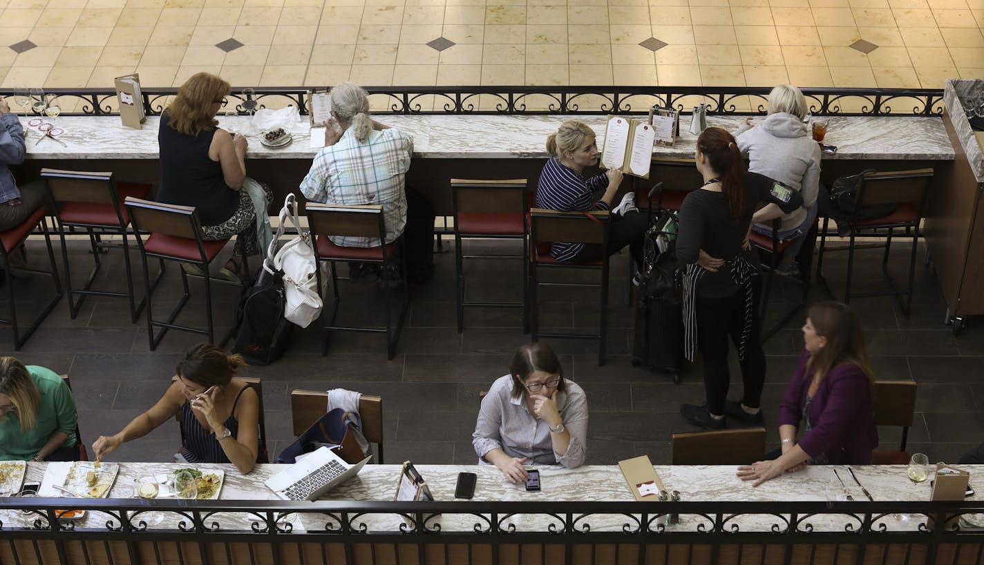 Patrons in the open seating area of Lake Wine Kitchen + Bar in the MSP Mall in the Lindbergh Terminal.