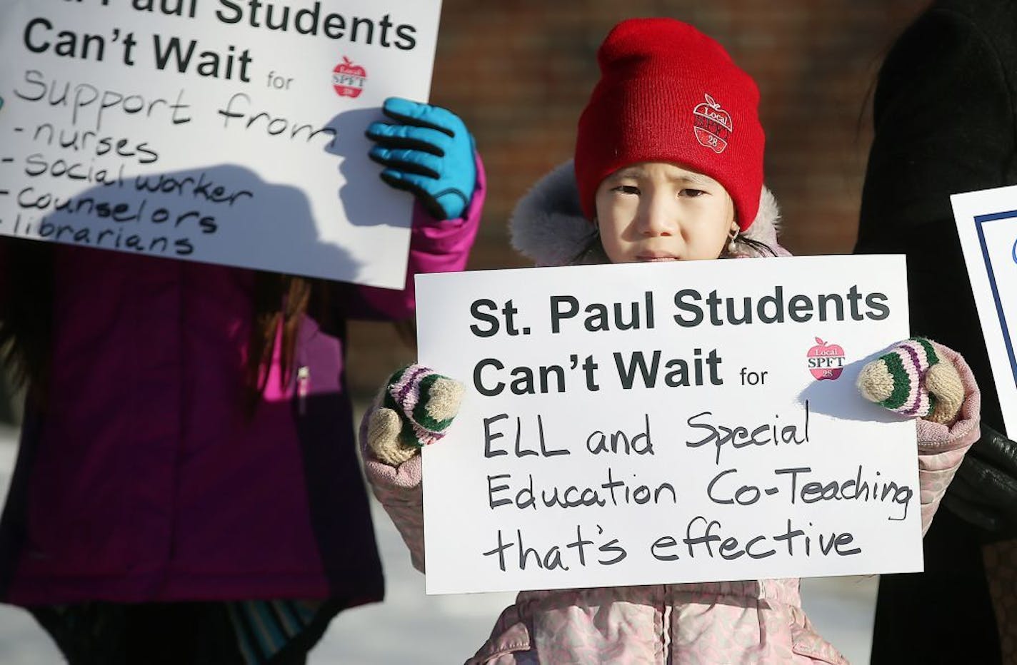 Gaoshiaxa Cha, 7, stood alongside her mother Maysy Ly-Lo, an ELL educational assistant, to support the St. Paul teachers union as they gathered at the American Indian Magnet School for a rally on Feb. 17 in St. Paul.