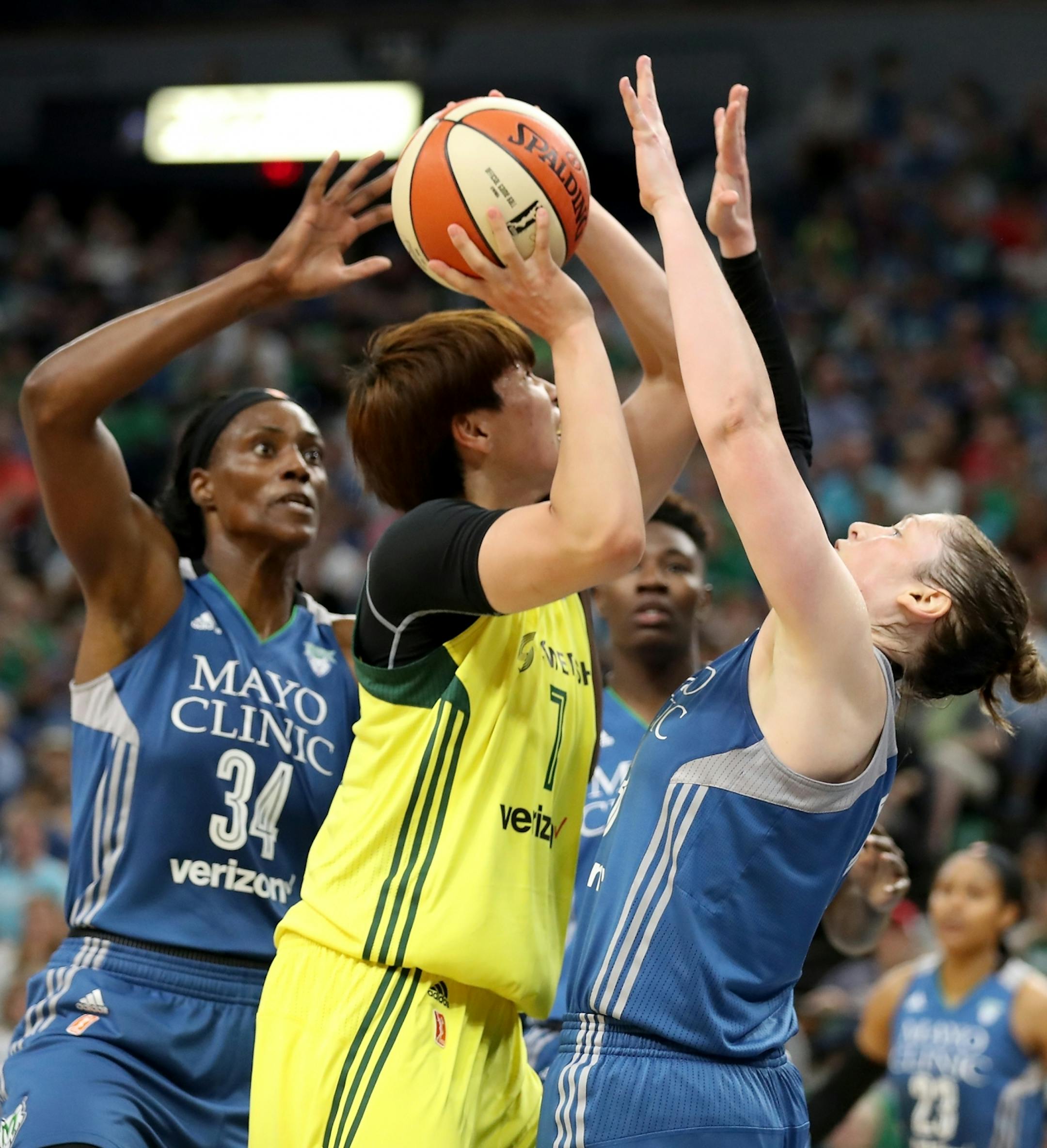 Seattle Storm forward Ramu Tokashiki (7), center, tries to shoot against the defense of Minnesota Lynx center Sylvia Fowles (34), left, and Minnesota Lynx guard Lindsay Whalen (13) during the first half.