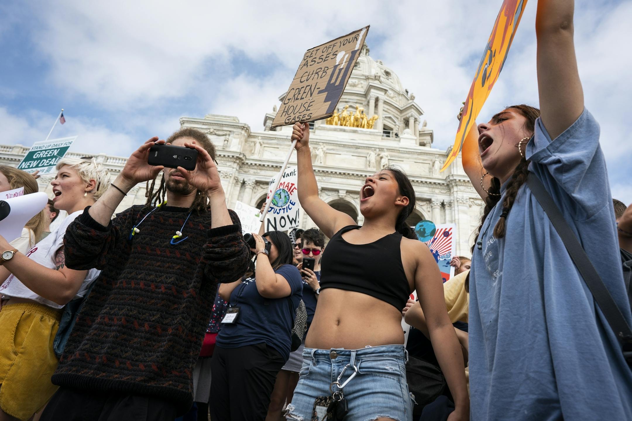 Marisa Koster, 17, of Eagan, center, and Liza Rotty, right, 17, of Apple Valley, chanted before the rally at the Capitol. They were part of a large group of student from School of Environmental Studies in Apple Valley.