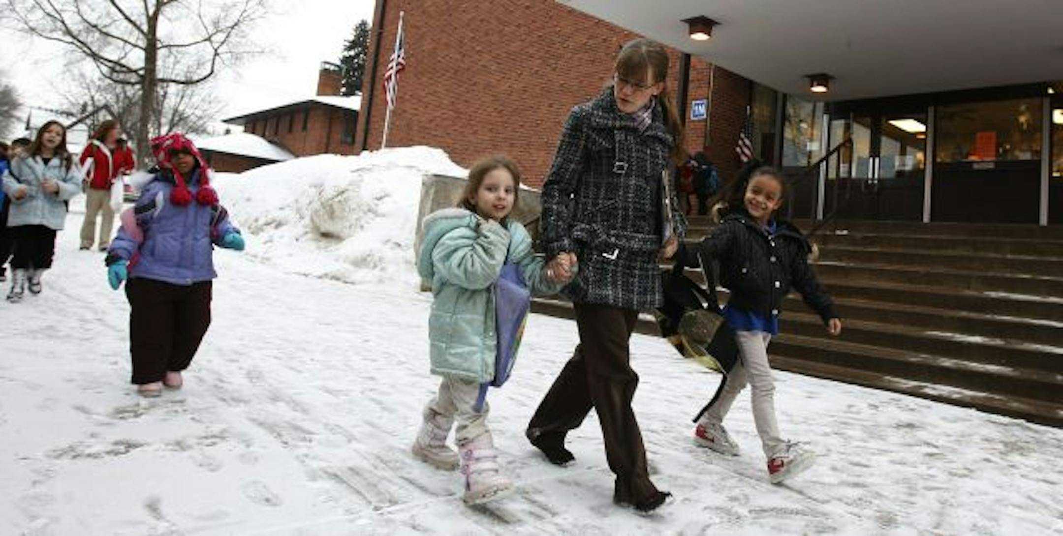 Alexis Gerrish, a kindergarten teacher at Concordia Creative Learning Academy in St. Paul, walked students Karah Smieja, left, and Amarianna Russell to their bus after school on Monday.