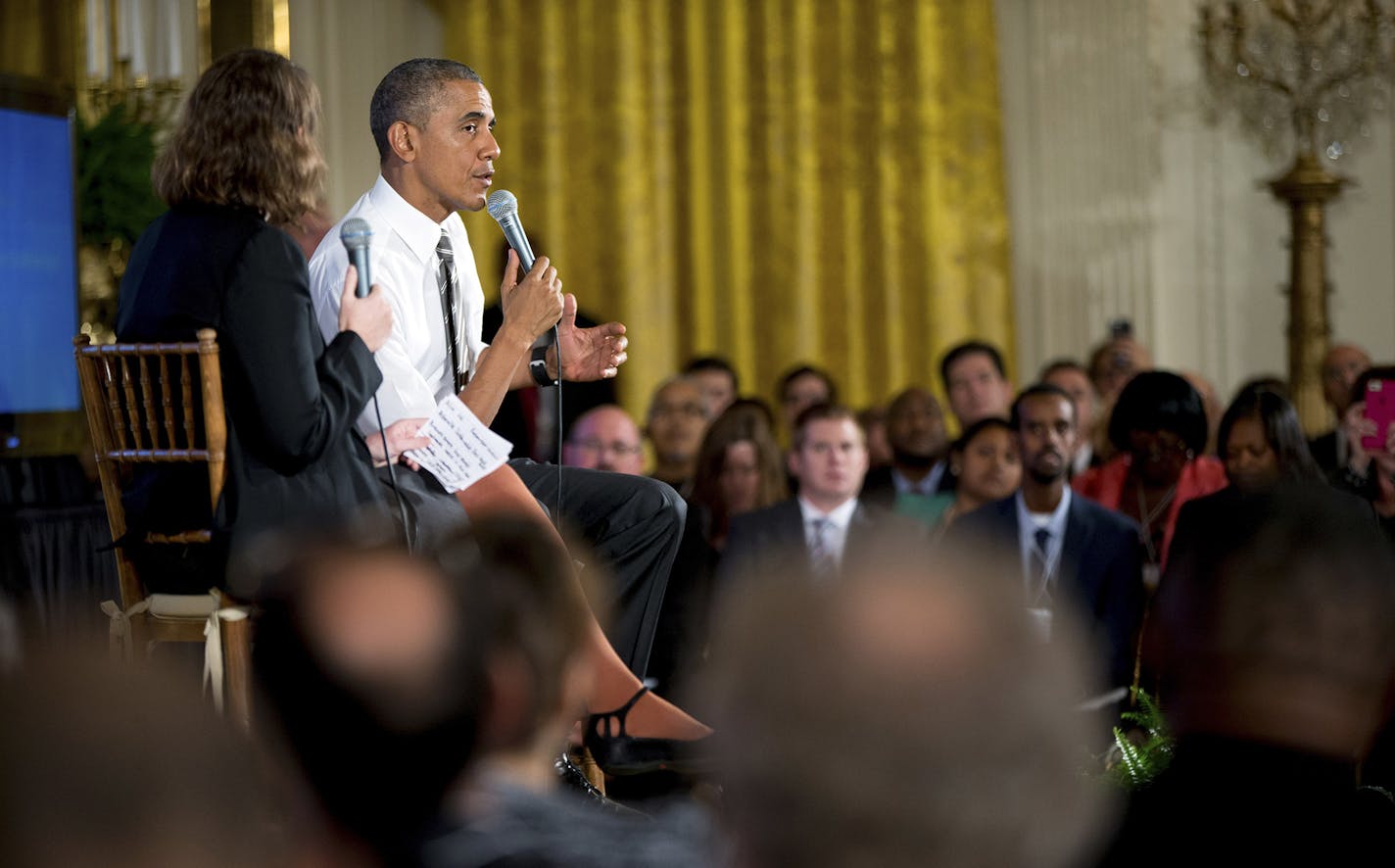 President Barack Obama, accompanied by Michelle Miller, co-founder of coworker.org, left, speaks during a conversation co-hosted by Coworker.org during the White House Summit on Worker Voice, Wednesday, Oct. 7, 2015, in the East Room of the White House in Washington. Workers, employers, unions, organizers and other advocates were meeting on how to energize a new generation of Americans to come together and recognize the potential power of their voice at work. (AP Photo/Andrew Harnik) ORG XMIT: D