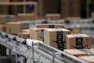 Packages passed down a conveyor belt before receiving a shipping label at Amazon in Shakopee.