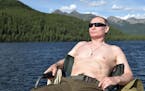In this photo released by Kremlin press service on Saturday, Aug. 5, 2017, Russian President Vladimir Putin rests after fishing during a mini-break in
