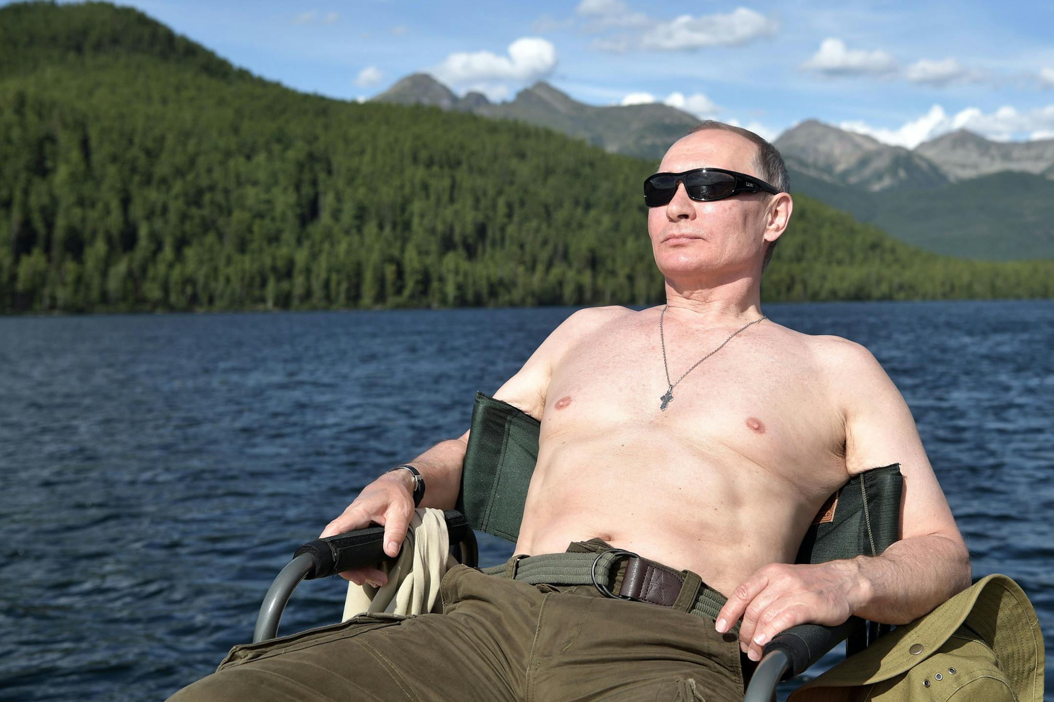 In this photo released by Kremlin press service on Saturday, Aug. 5, 2017, Russian President Vladimir Putin rests after fishing during a mini-break in the Siberian Tyva region, a few days ago. (Alexei Nikolsky/Sputnik, Kremlin Pool Photo via AP)