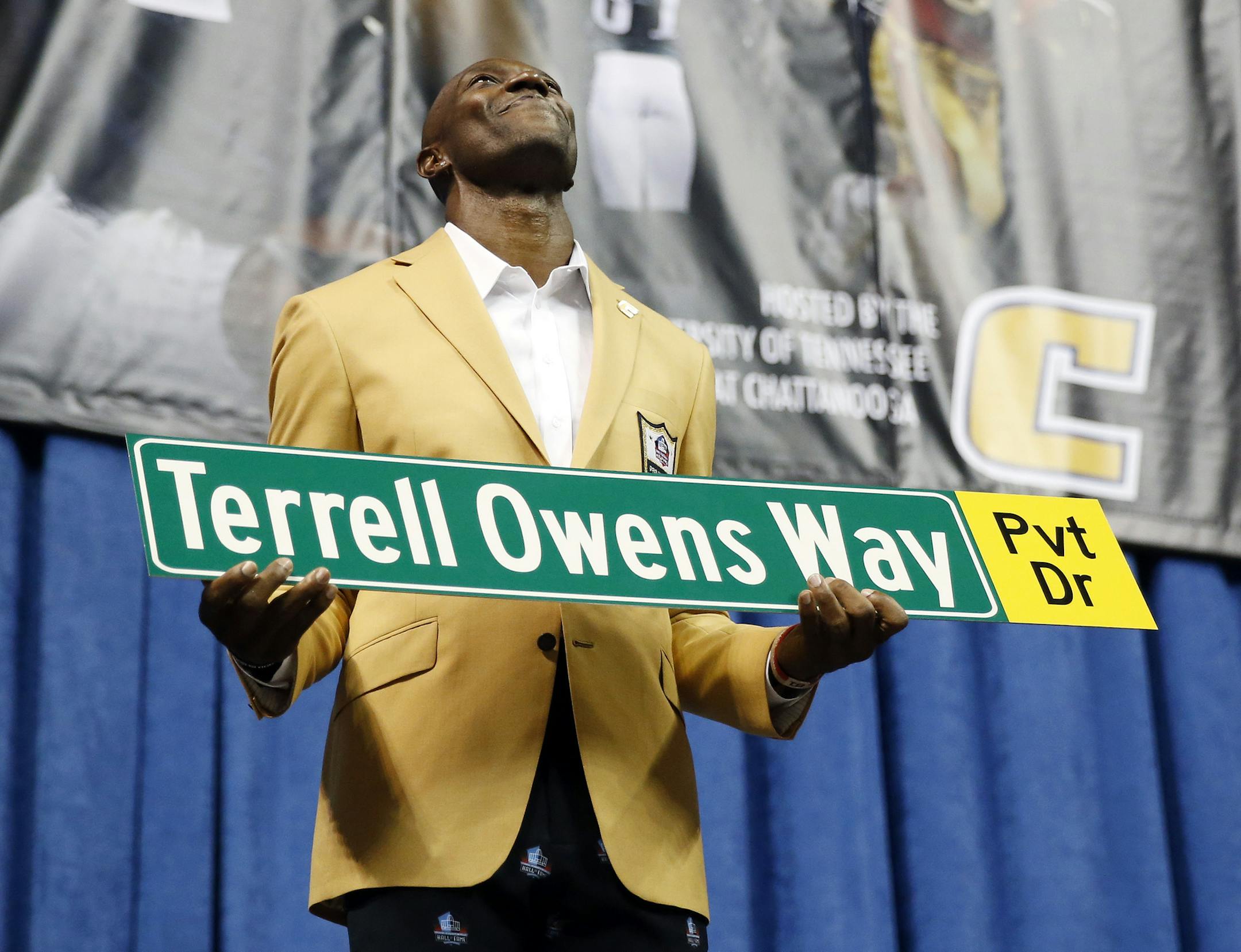Former wide receiver Terrell Owens holds a street sign after a road was named for him following his Pro Football Hall of Fame speech, Saturday, Aug. 4, 2018, in Chattanooga, Tenn. Instead of speaking at the Hall of Fame events in Canton, Ohio, Owens celebrated his induction at the University of Tennessee at Chattanooga, where he played football and basketball and ran track. (AP Photo/Mark Humphrey)