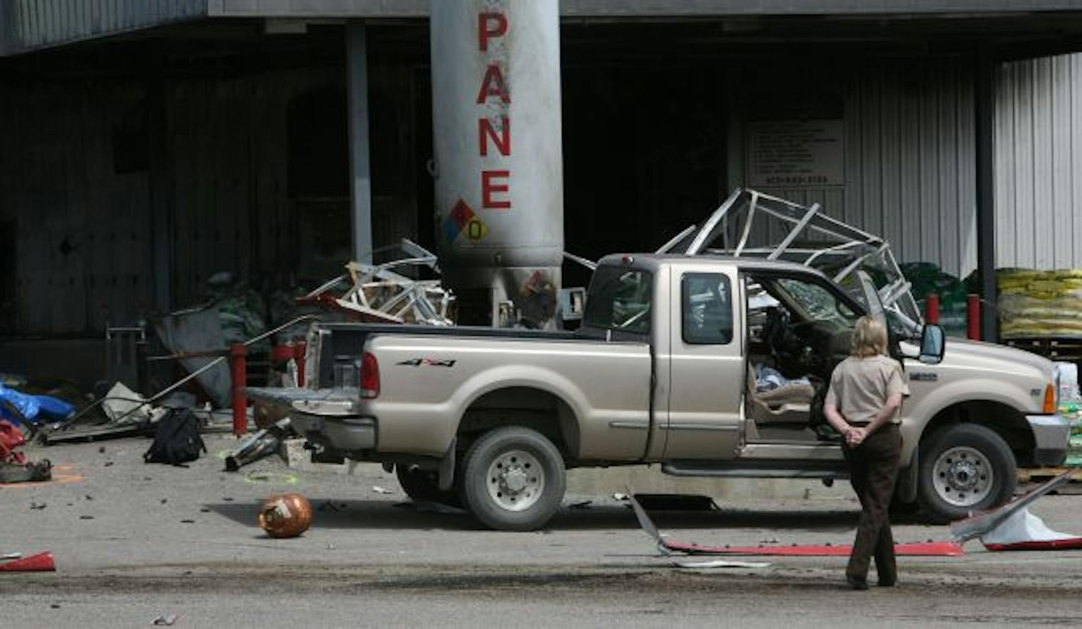 A member of the Carver County Sheriff's Office examined the debris left by the blast. The explosion inside the shack sent shrapnel flying hundreds of yards, damaging the store and cars parked in the company lot.