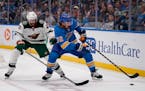 St. Louis Blues' Justin Faulk (72) and Minnesota Wild's Alex Goligoski (47) chase after a loose puck along the boards during the third period of an NH