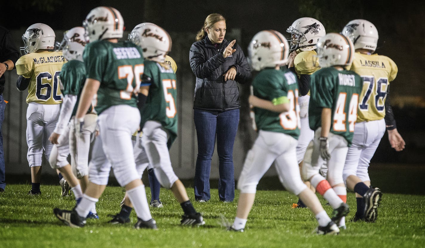 Stephanie Miske, a sign language interpreter, signs to deaf player Dov Nathanson during a White Bear Lake youth football game at Podvin Park in White Bear Lake on Monday, October 5, 2015. ] (LEILA NAVIDI/STAR TRIBUNE) leila.navidi@startribune.com BACKGROUND INFORMATION: It's been 25 years since the passage of the American with Disabilities Act, yet the Nathanson family says it is still a near constant battle to have access to the same schools and sporting opportunities as other suburban families