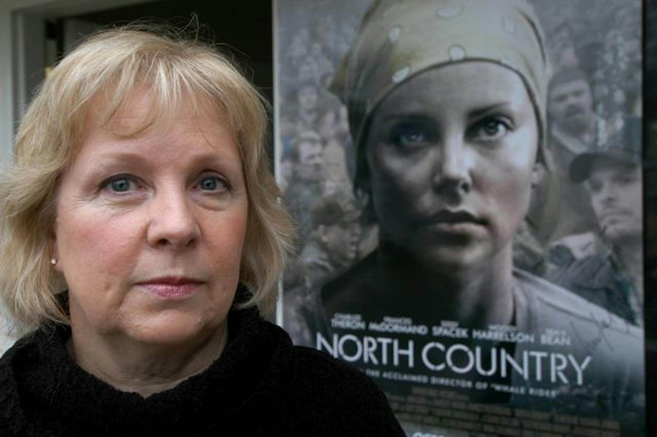 Lois Jenson at home with an autographed movie poster given to her by the cast of North Country.