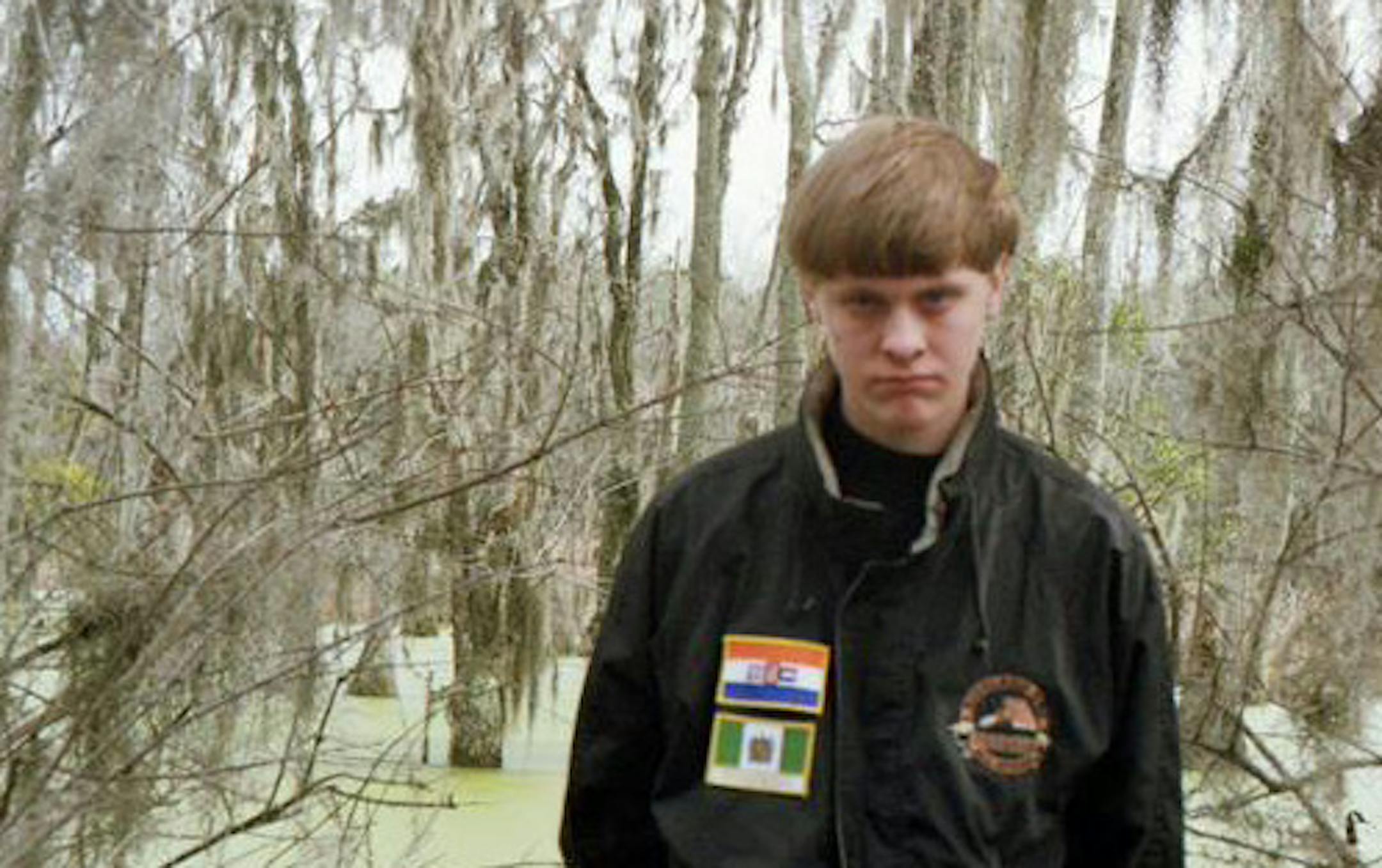 Dylann Storm Roof, wearing a jacket with the flags of apartheid-era South Africa and Rhodesia, is accused of shooting nine people dead at a black church in Charleston, S.C.