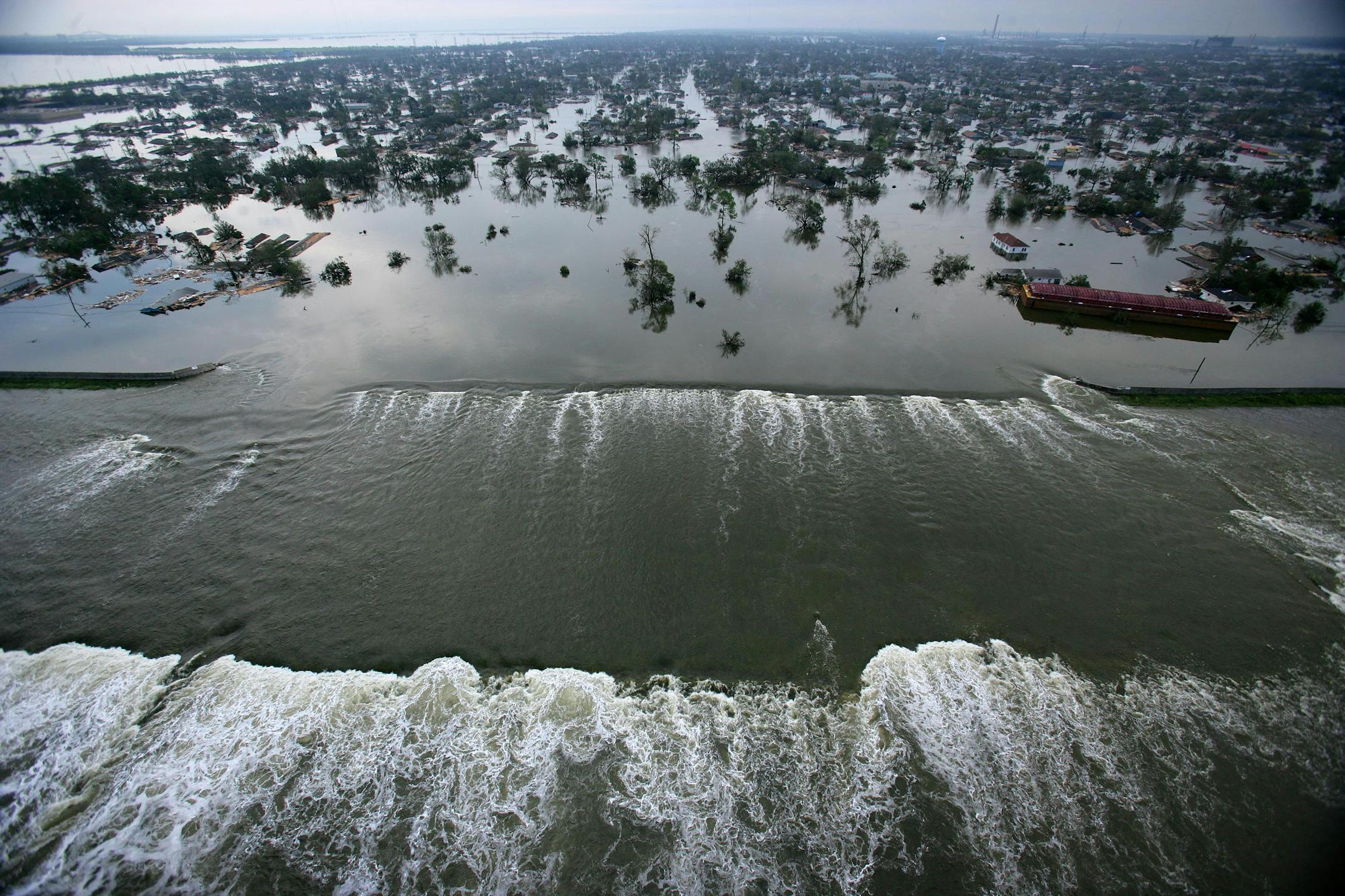 Floodwaters from Hurricane Katrina pour through a levee along Inner Harbor Navigational Canal near downtown New Orleans on Aug. 30, 2005, a day after Katrina passed through the city.