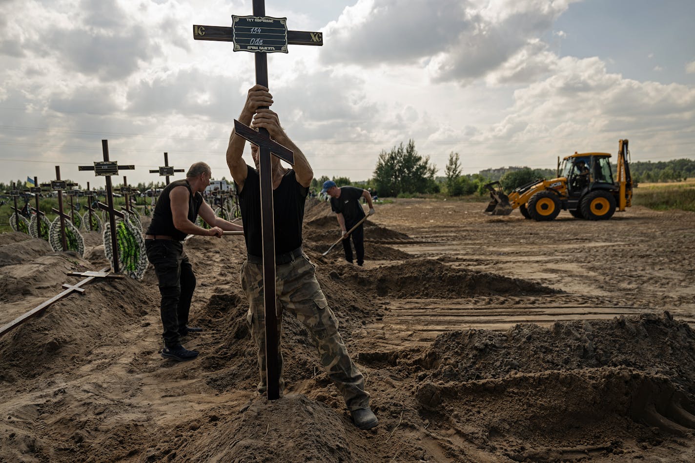 BUCHA, UKRAINE — BC-OPINION-CHEKH-UKRAINE-SOLDIER-ART-NYTSF — A mass burial in Bucha, Ukraine, this month. (Lynsey Addario for The New York Times) — ONLY FOR USE WITH ARTICLE SLUGGED — BC-OPINION-CHEKH-UKRAINE-SOLDIER-ART-NYTSF — OTHER USE PROHIBITED.